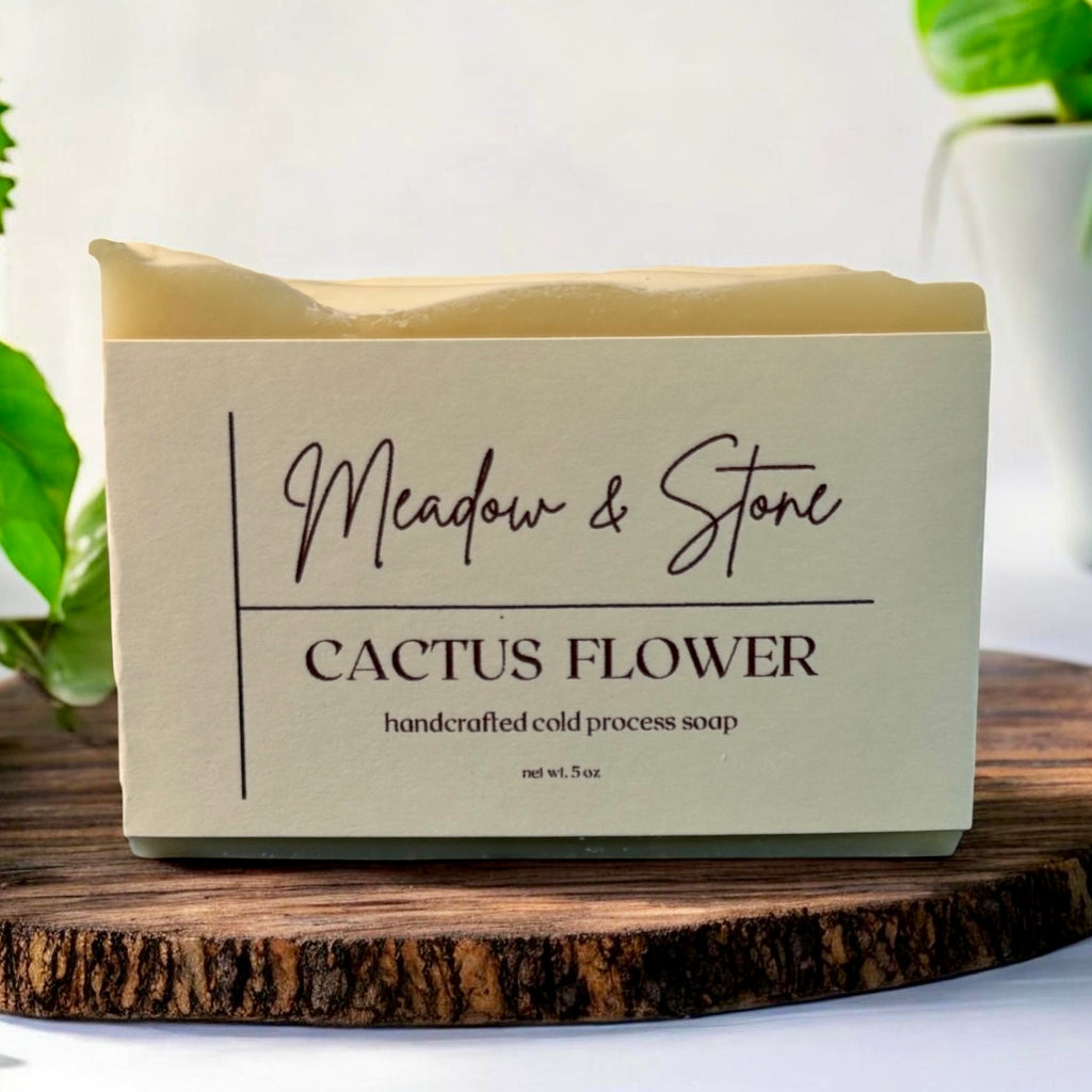 Meadow & Stone Cactus Flower soap bar on a wooden surface with plants in the background
